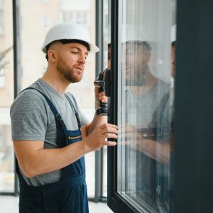 Construction worker installing window in house